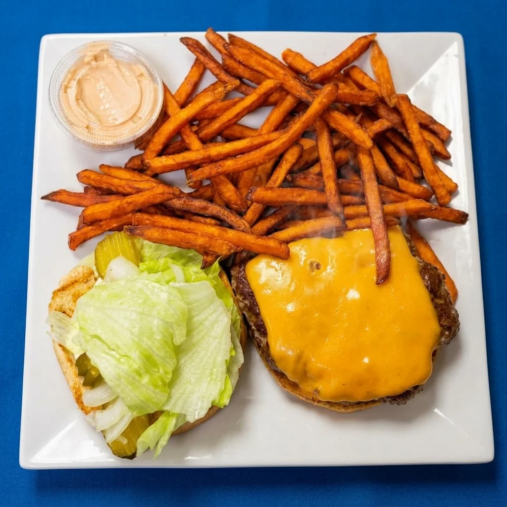 Cheeseburger with lettuce, tomato and red onion on a sesame bun at Cheryl's Country Kitchen in Airdrie, AB