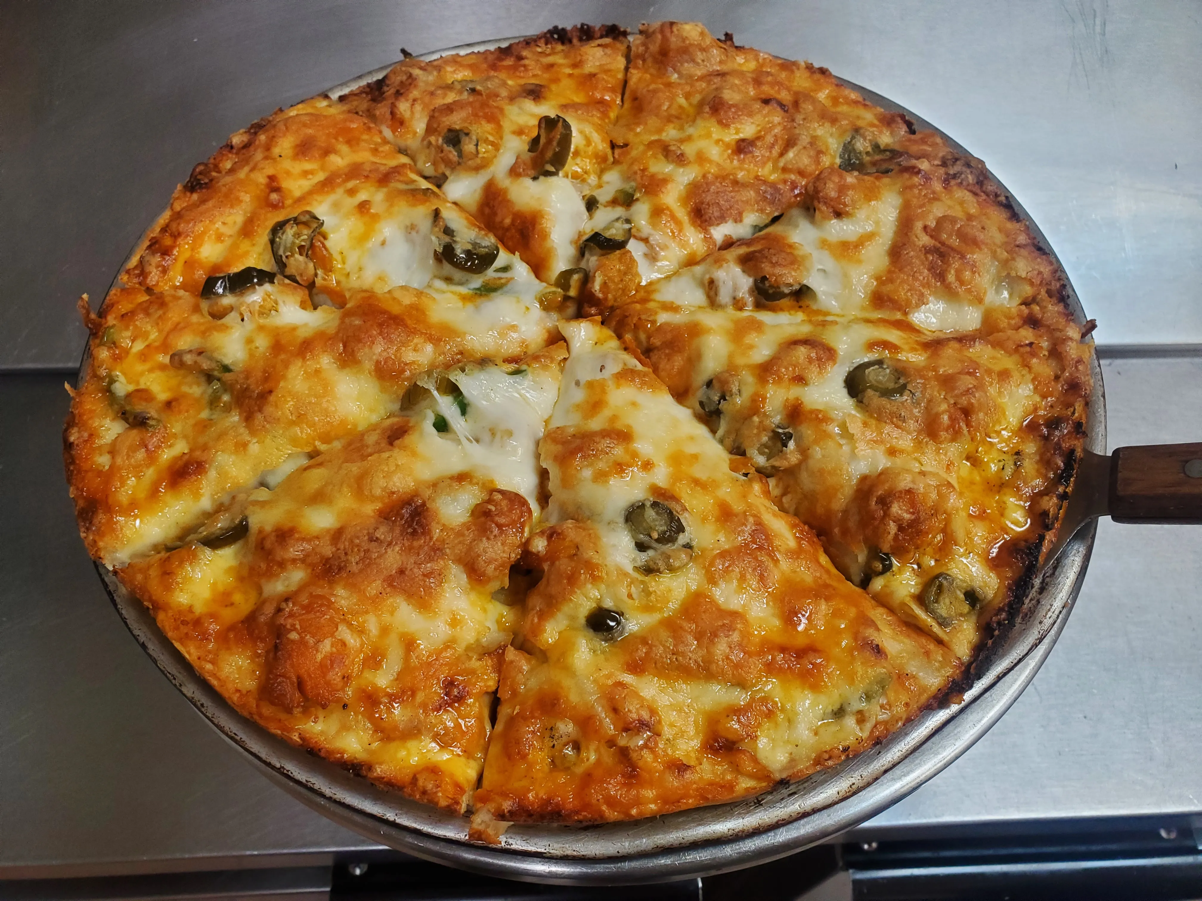 Hand-stretched pizza baked golden with bubbling mozzarella at Cheryl's Country Kitchen in Airdrie, AB
